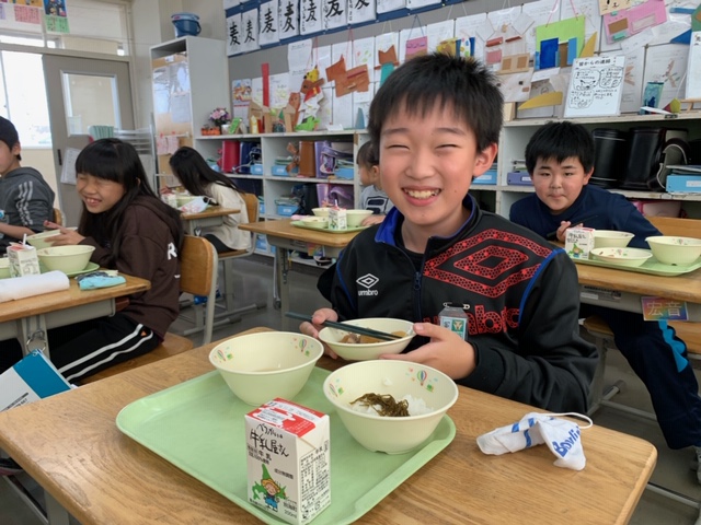 笑顔で給食を頬張る児童