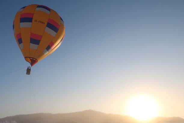 朝日を浴びて飛行する熱気球
